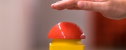 Hand über rotem Notfall-Buzzer